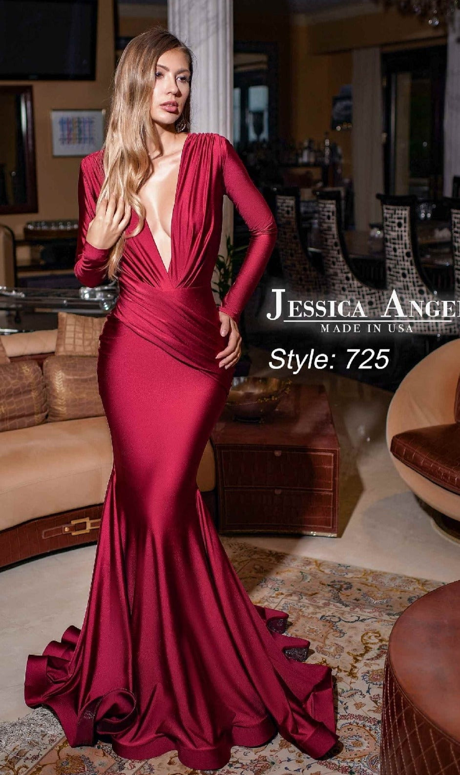 A woman poses indoors in the Jessica Angel 725: a deep red long formal dress with long sleeves and a plunging neckline.